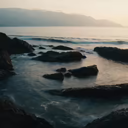 a rocky shore line next to a body of water