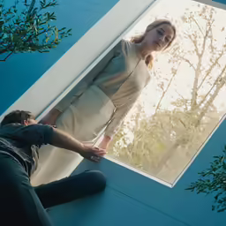 two people standing against a wall next to each other