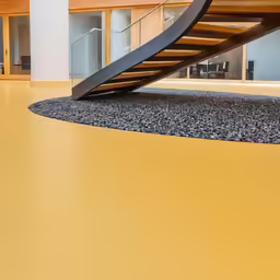 a winding staircase in a large room that is yellow