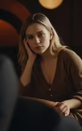 a woman sitting and holding her head