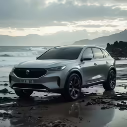 a silver suv on shore next to ocean