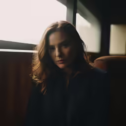 a woman sitting in the back seat of a train
