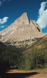 a group of mountains with trees and blue skies