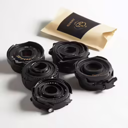 there are six cameras sitting next to a piece of brown paper