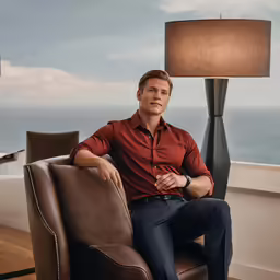 a man sitting in a chair by the ocean
