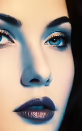 a woman with dark blue makeup and blue eyes