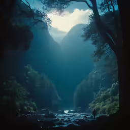 a man walking in the middle of a river surrounded by tall trees
