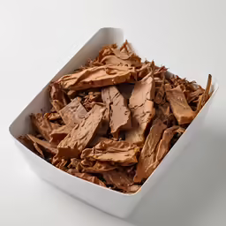 chunks of chocolate chips sit in a white square container