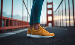 a person with a tennis shoe standing near a bridge