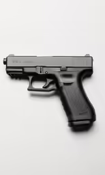 black gun lying on white background with reflection