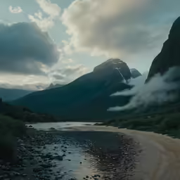 a river running along the shore of a mountain range