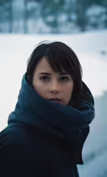 woman in black jacket and scarf staring to camera
