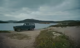 the truck is parked near a body of water