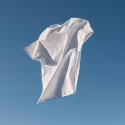 an open white flag flying in a blue sky