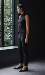 a woman stands in front of an open window