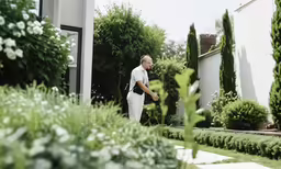 a man in white pants and shirt in front of a house