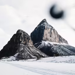 a pair of mountains on top of a snowy mountain range