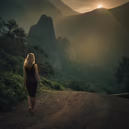the woman is walking along a mountain trail