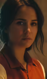 the woman in the red shirt is looking into the camera