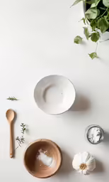 this is a white bowl and spoon, surrounded by small bowls