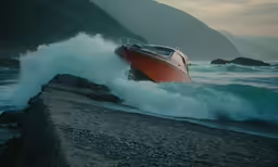 a small boat is crashing on the rocks by the water