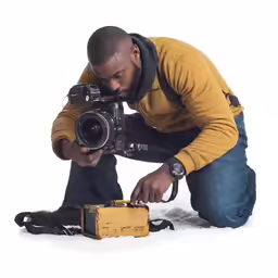 a person kneeling down next to a camera