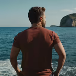 a man looks at the ocean while standing on his boat
