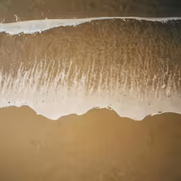 the top view of an ocean wave and beach
