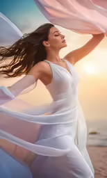 a woman wearing a long white dress poses on the beach with the sun setting behind her