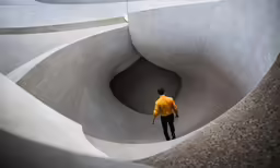 the man is looking at the concrete structure