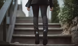 woman running up some stairs in a dark jacket