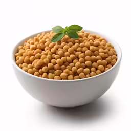 a bowl full of small yellow beads with a leaf in it