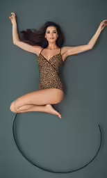 a woman in a black bodysuit and an animal print leor