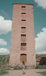 a person standing in front of an odd looking tower
