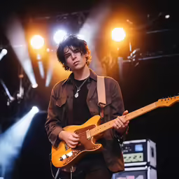 a man with a guitar at an outdoor concert