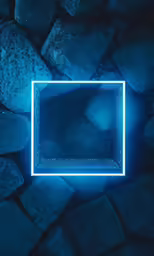 an illuminated frame on a pile of rocks