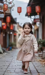a young girl wearing a trench coat on a brick sidewalk