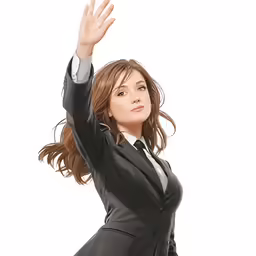 the woman is dressed in a suit and has her arms raised