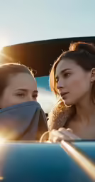 two women in a car at sunset