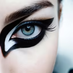 the face of a woman with blue eyes and long eyelashes