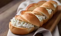 a long braided hot dog bun covered in cream cheese