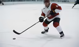 a young hockey player running with the puck