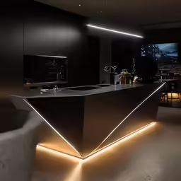 the kitchen has a large long bar illuminated with led lights
