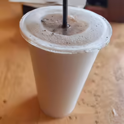 a beverage in a paper cup on a table