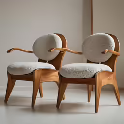 two wood and white chairs sitting next to each other