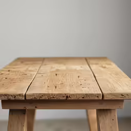the edge of an old wooden table with a single section missing