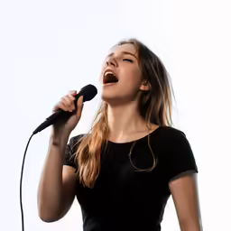a girl singing into a microphone and holding a microphone