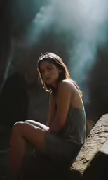 the woman is sitting on the edge of a rock