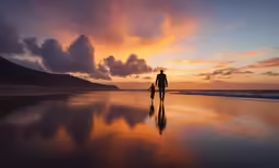 a lone man standing on the beach while looking out over the ocean