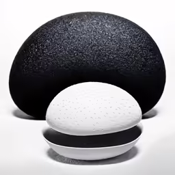 three black and white rocks with one round on the floor